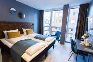 a bedroom with two beds and a large window at The Verdandi Hotel in Oslo