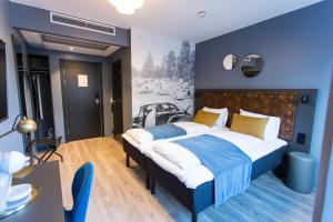 1 dormitorio con 1 cama grande y pared azul en The Verdandi Hotel, en Oslo