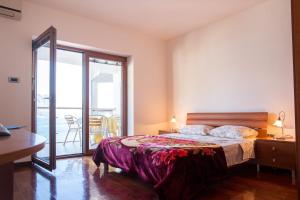 ein Schlafzimmer mit einem Bett und einem Balkon in der Unterkunft Lux Panoramic Apartment in Budva