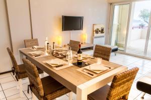 a dining room with a table with chairs and a television at Front de Mer in Hendaye