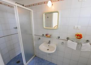 a white bathroom with a sink and a shower at Villa Maria Antonietta in Positano