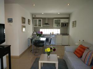 a living room with a couch and a table with flowers on it at Apartamentos Arcos del Esva in Luarca