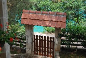 a wooden gate with a red roof over a fence at Hotel Art Media in Herceg-Novi