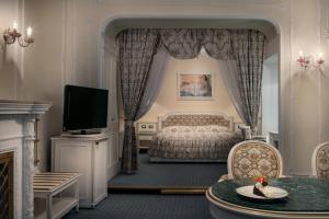 a bedroom with a bed and a flat screen tv at Ambassador Zlata Husa in Prague