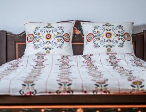 Una cama con sábanas blancas y almohadas. en Casa Kraus, en Criţ