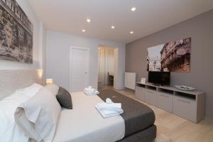 um quarto com uma grande cama branca e uma televisão de ecrã plano em Taranta Suite em Lecce
