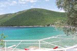 a boat in the water with a mountain in the background at Hotel Art Media in Herceg-Novi