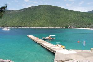 a boat is docked at a dock in the water at Hotel Art Media in Herceg-Novi