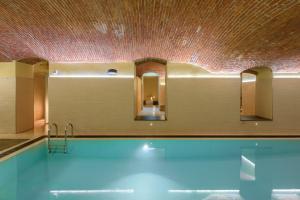 a bathroom with a swimming pool and a ceiling with mirrors at Residenza Porta Volta in Milan