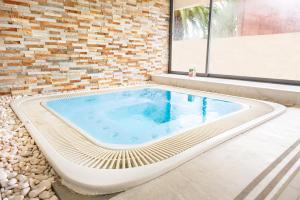 - une grande piscine dans une pièce dotée d'un mur en briques dans l'établissement Hotel dos Zimbros, à Sesimbra