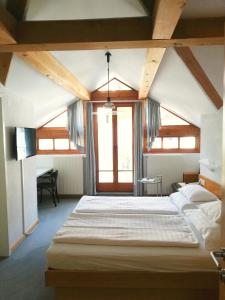 a bedroom with two beds and a large window at Gasthof Falkeis in Kauns