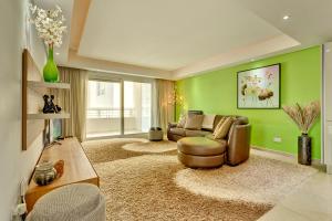 スリーマにあるLuxury Apartment inc Pool & Viewsの緑の壁のリビングルーム(ソファ付)