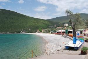 a beach with a boat on the shore at Hotel Art Media in Herceg-Novi