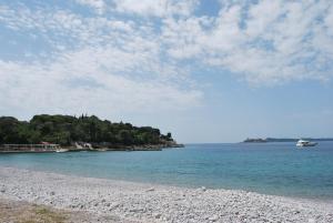 a beach with a boat in the water at Hotel Art Media in Herceg-Novi