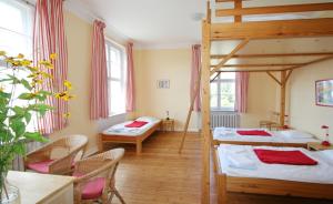 Zimmer mit 2 Etagenbetten sowie einem Tisch und Stühlen in der Unterkunft Familien- und Freizeithotel Gutshaus Petkus in Petkus
