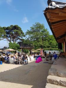 Une foule de personnes assises sur des chaises dans un parc dans l'établissement Jukheon Traditional House, à Andong