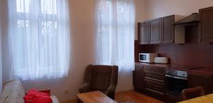 eine Küche mit einem Stuhl und einem Tisch sowie einige Fenster in der Unterkunft Sweet Kato Apartment in Kattowitz