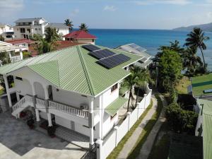 una vista aérea de una casa con paneles solares en el techo en Drake Seaside Studio Apartments en Bel Ombre