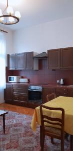 a kitchen with wooden cabinets and a table with a yellow tablecloth at Sweet Kato Apartment in Katowice