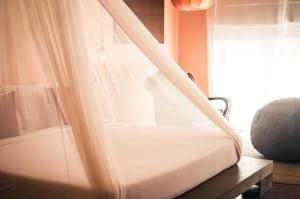 a bed in a room with a curtain at iRoHa Garden Hotel & Resort in Phnom Penh