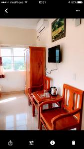 a dining room with a table and chairs and a television at Hoang Kim Ha Giang Hotel in Ha Giang