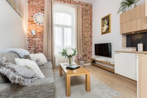 a living room with a couch and a brick wall at Angleterre Apartments in Tallinn
