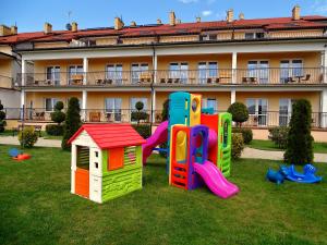 a group of play equipment in the grass in front of a building at Bursztynowy Brzeg in Sarbinowo