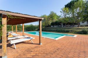a swimming pool with a pavilion next to a house at Podere Le Capannucce in Pontedera
