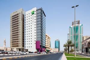 a street in a city with tall buildings at ibis Styles Sharjah in Sharjah