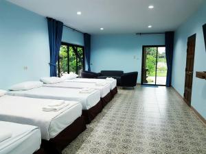 szereg łóżek w pokoju z niebieskimi ścianami w obiekcie Sophia Resort w mieście Ban Wang Takhrai