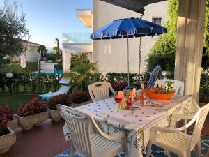 シルミオーネにあるYour Perfect Placeのパティオに置かれたテーブルと椅子、そして傘