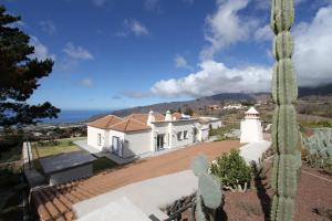 Villa Javier La Palma في إل باسو: بيت ابيض فيه صبار في المقدمة