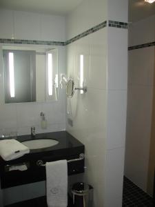 a white bathroom with a sink and a mirror at Biznis Hotel in Lokeren