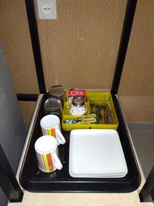taca z kubkami i innymi przedmiotami na stole w obiekcie Room for 2 w Szawlach
