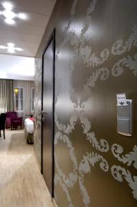 a wall with a white stenciled design on it at Biznis Hotel in Lokeren