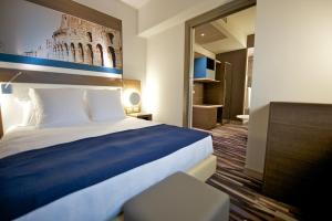 a hotel room with a bed and a mirror at Mercure Roma Centro Colosseo in Rome