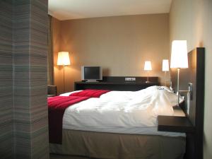 a hotel room with a bed and a television at Biznis Hotel in Lokeren
