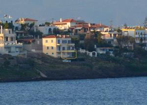 a group of houses on a hill next to the water at Ithaca in Perdika