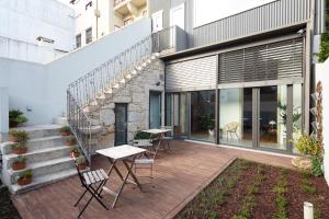 a patio area with chairs, tables, and a walkway at Trindade Premium Suites & Apartments in Porto