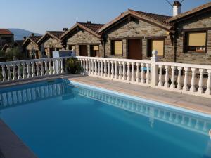 uma piscina em frente a uma casa com uma cerca em Posadas De Granadilla em Zarza de Granadilla
