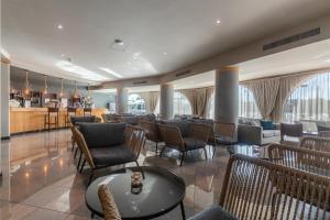 a lobby with chairs and tables and a bar at Luna Solaqua in Albufeira
