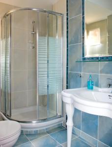 a bathroom with a shower and a sink and a toilet at Hotel Chronis in Paralia Katerinis