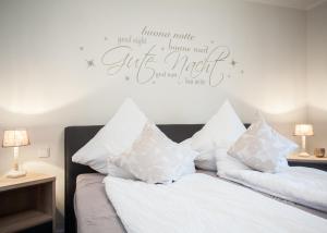 ヴィンターベルクにあるAppartement Fichtenweg 31-Bの白い枕と治癒の無視を読むサイン付きのベッド
