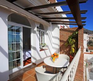 einen Balkon mit einem Tisch und Stühlen auf einem Gebäude in der Unterkunft Hotel Casa Rosa in Benalmádena