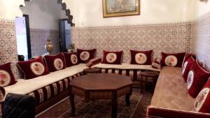 uma sala de estar com um sofá e almofadas vermelhas em Dar Soraya al Madina Marrakech em Marrakech