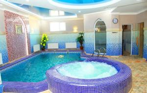 una gran piscina con bañera de hidromasaje en una habitación en Zarafshan Grand Hotel FIEZ, en Malik
