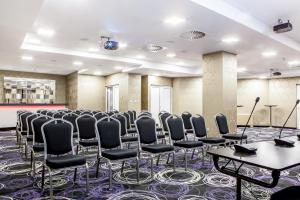 a room with rows of chairs and tables and a stage at Hotel Central Sarajevo in Sarajevo