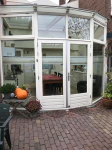 a white conservatory with a table inside of it at B&B De Duinhoek in Beverwijk