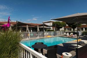a swimming pool on a balcony with an umbrella at Novotel Lyon Bron in Bron