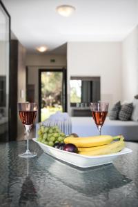 un piatto di frutta su un tavolo con due bicchieri da vino di Gmare a Gerakini